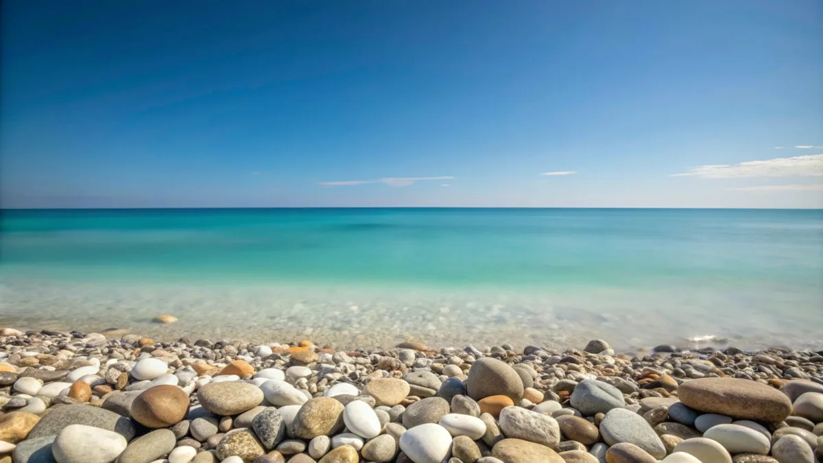 vue sur la mer avec une plage de galets sous un ciel bleu